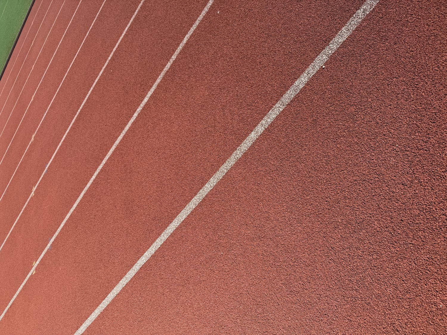 Diagonal lane lines on a red track surface