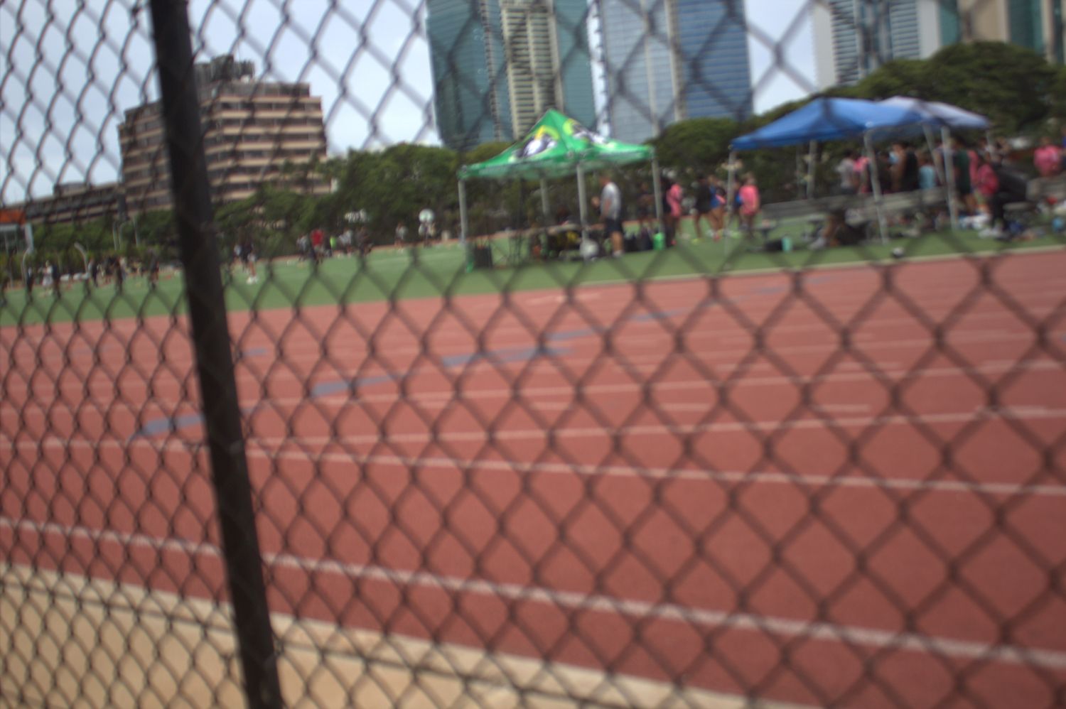 Track meet through the fence with canopy tents