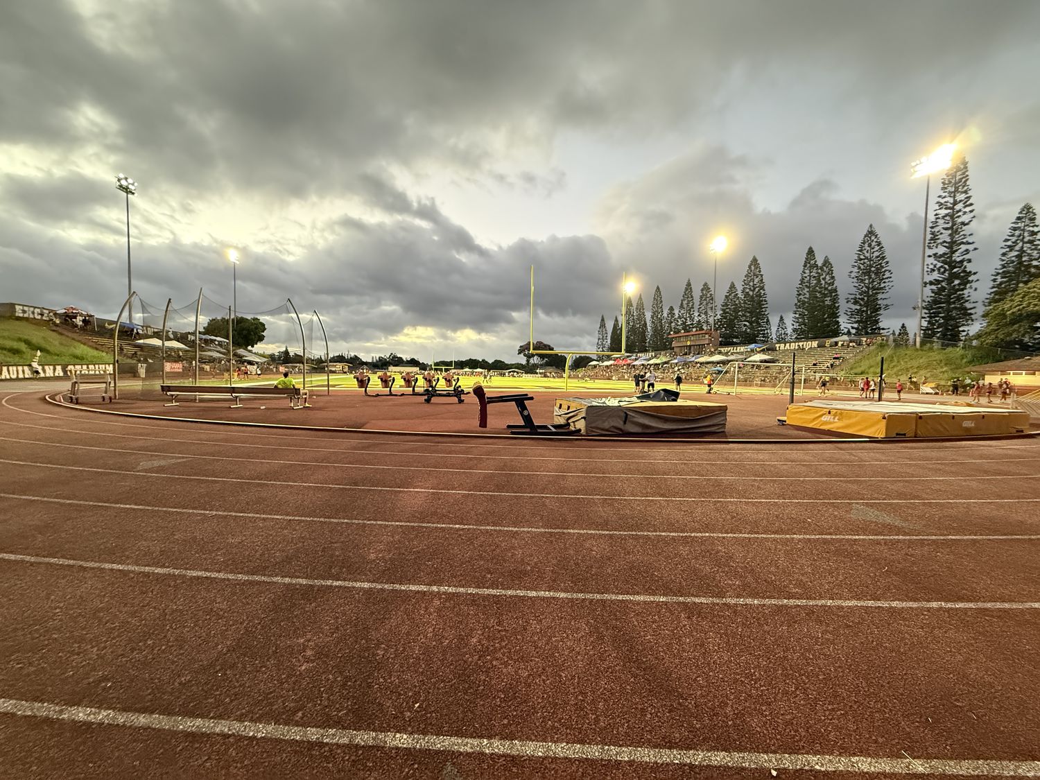 Track stadium at dusk with field events