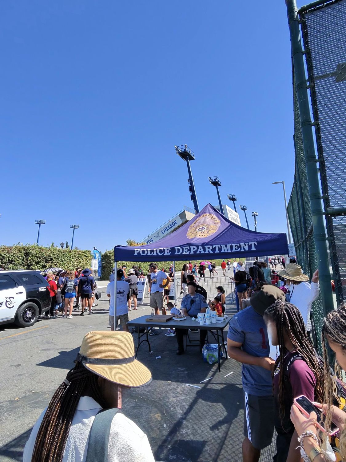 Busy scene near the entrance of the USATF Junior Olympics showing police, families, and athletes reuniting