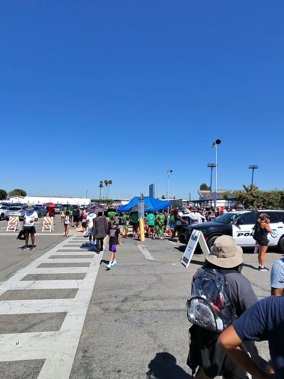 Parking lot and entrance area at Cerritos College during the USATF Junior Olympics showing crowds and police presence